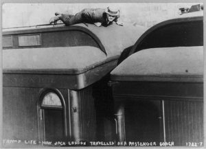 Hobo riding atop a box car.