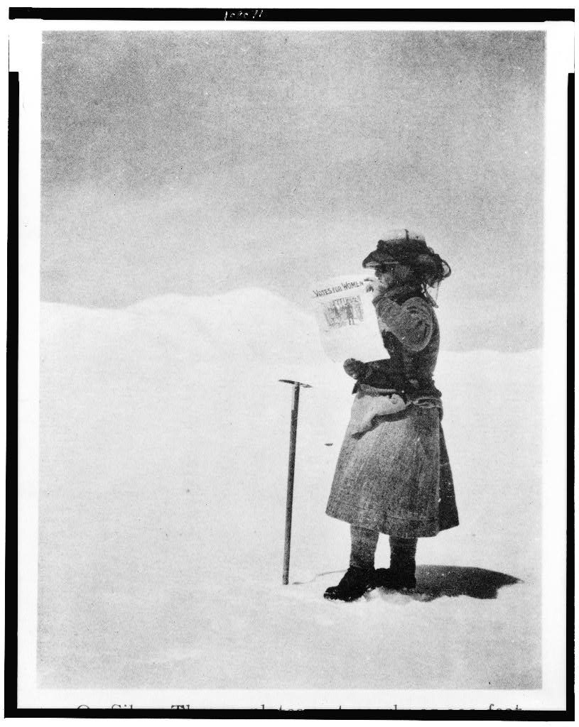 Fanny Workman holding a paper with the headline, "Votes for Women."